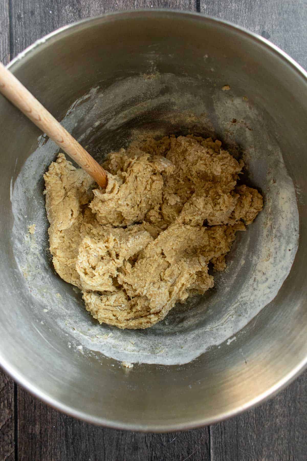 Bread dough mixed in a large metal bowl. 