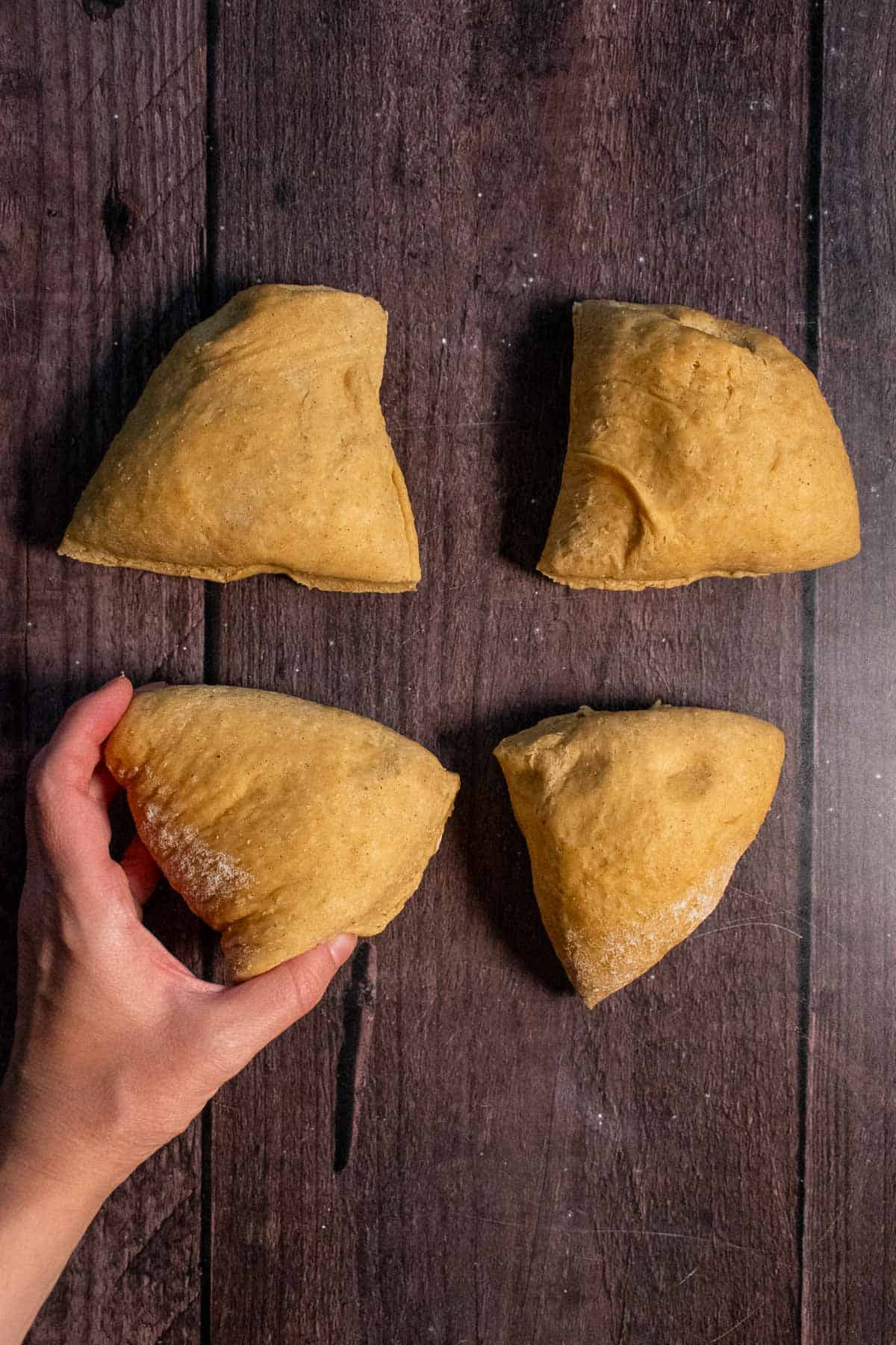 Four pieces of bread dough on a table. 