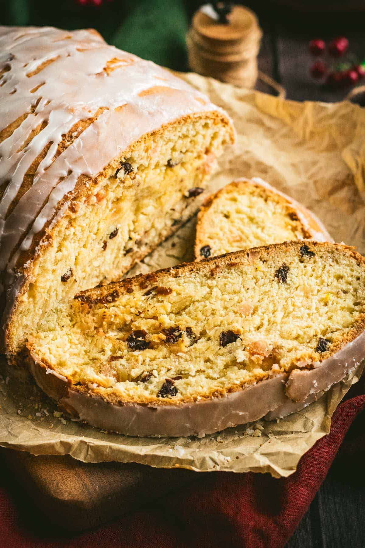 Two slices of fruit-filled yeast bread next to the rest of the loaf.