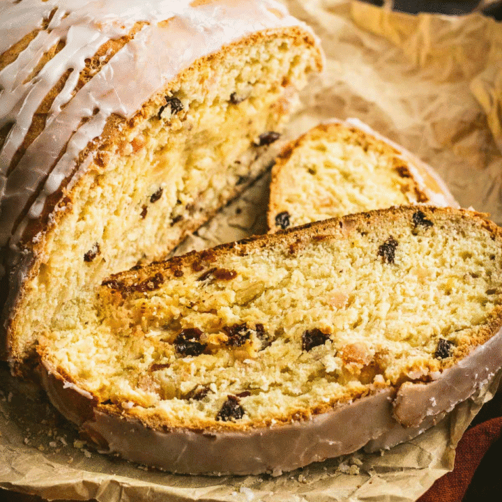 Two slices of Christmas stollen on a sheet of parchment paper.