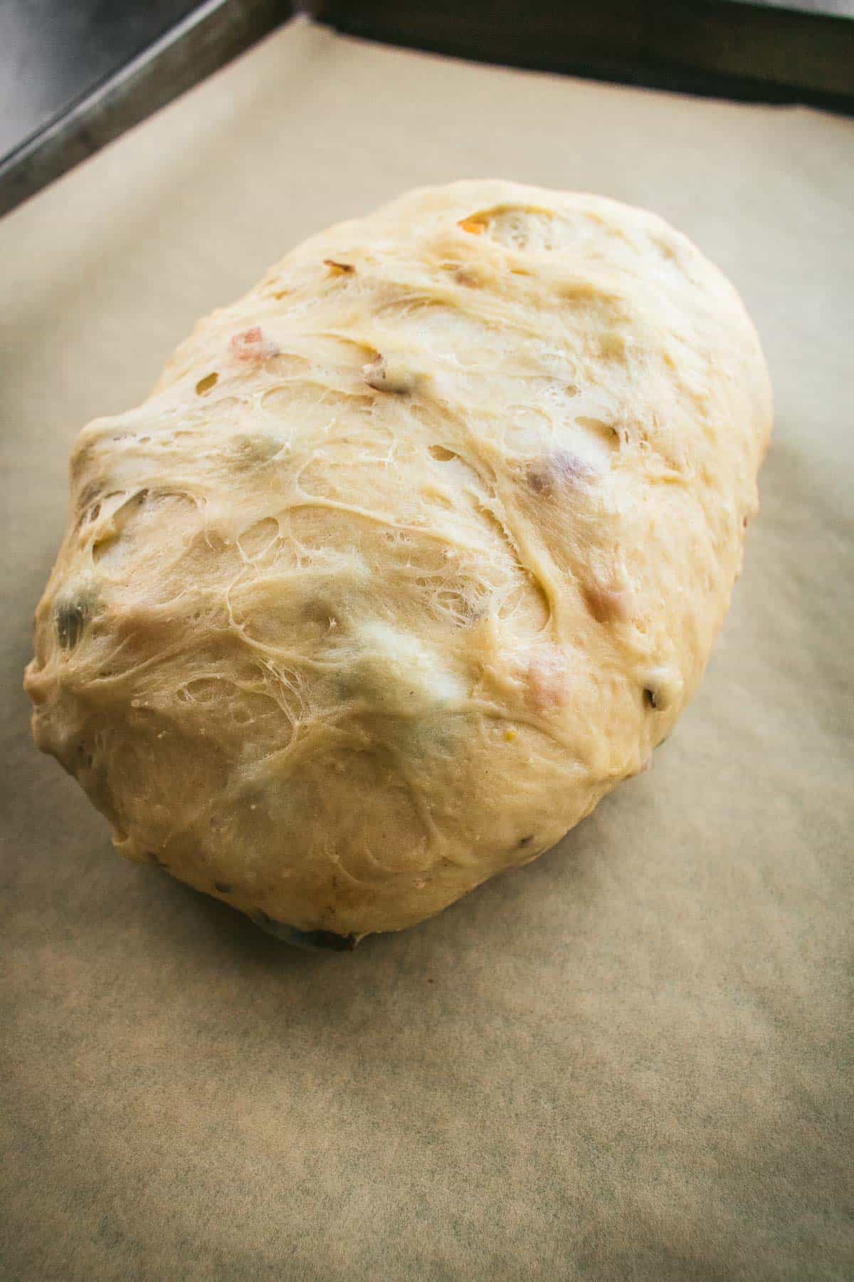 An oval of dough proofing on a baking sheet.