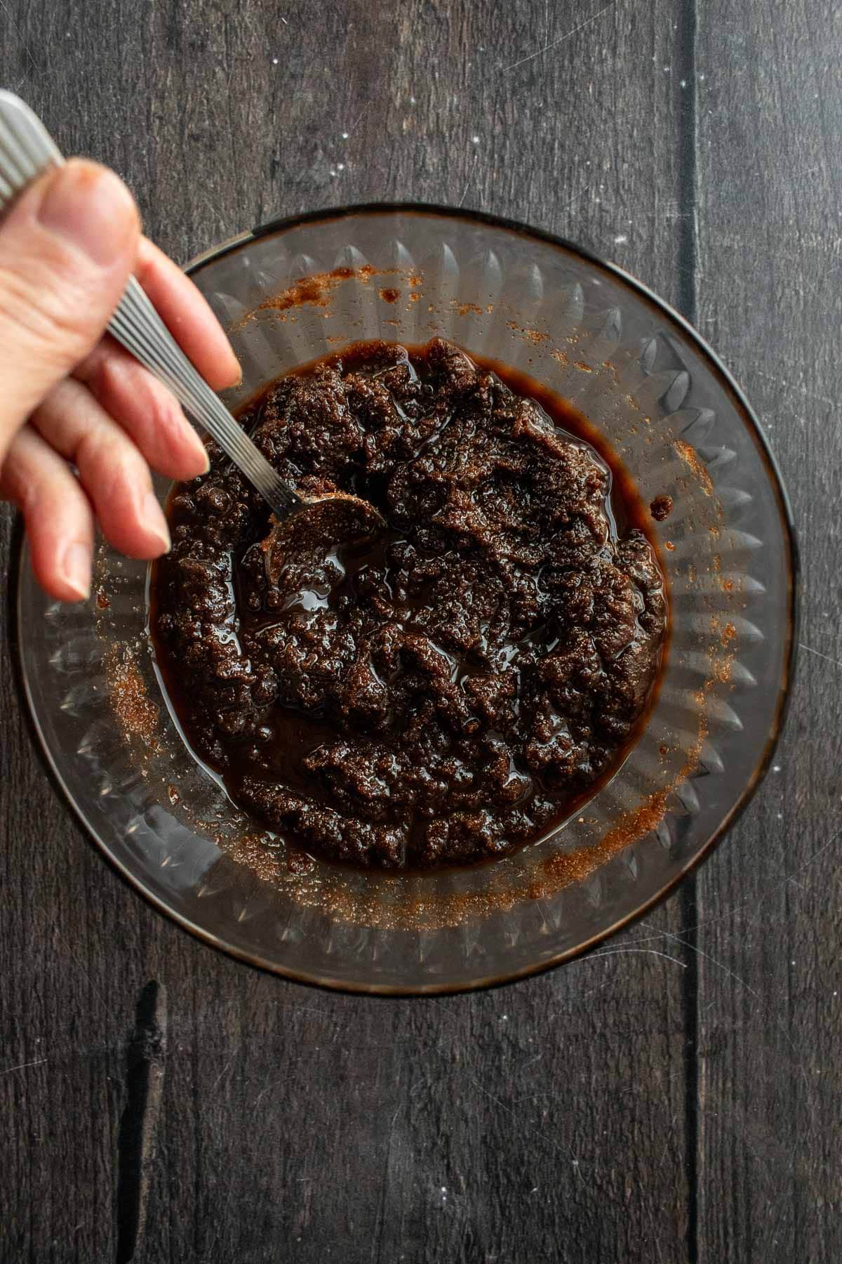 A dark brown mixture of melted butter and sugar in a glass bowl.