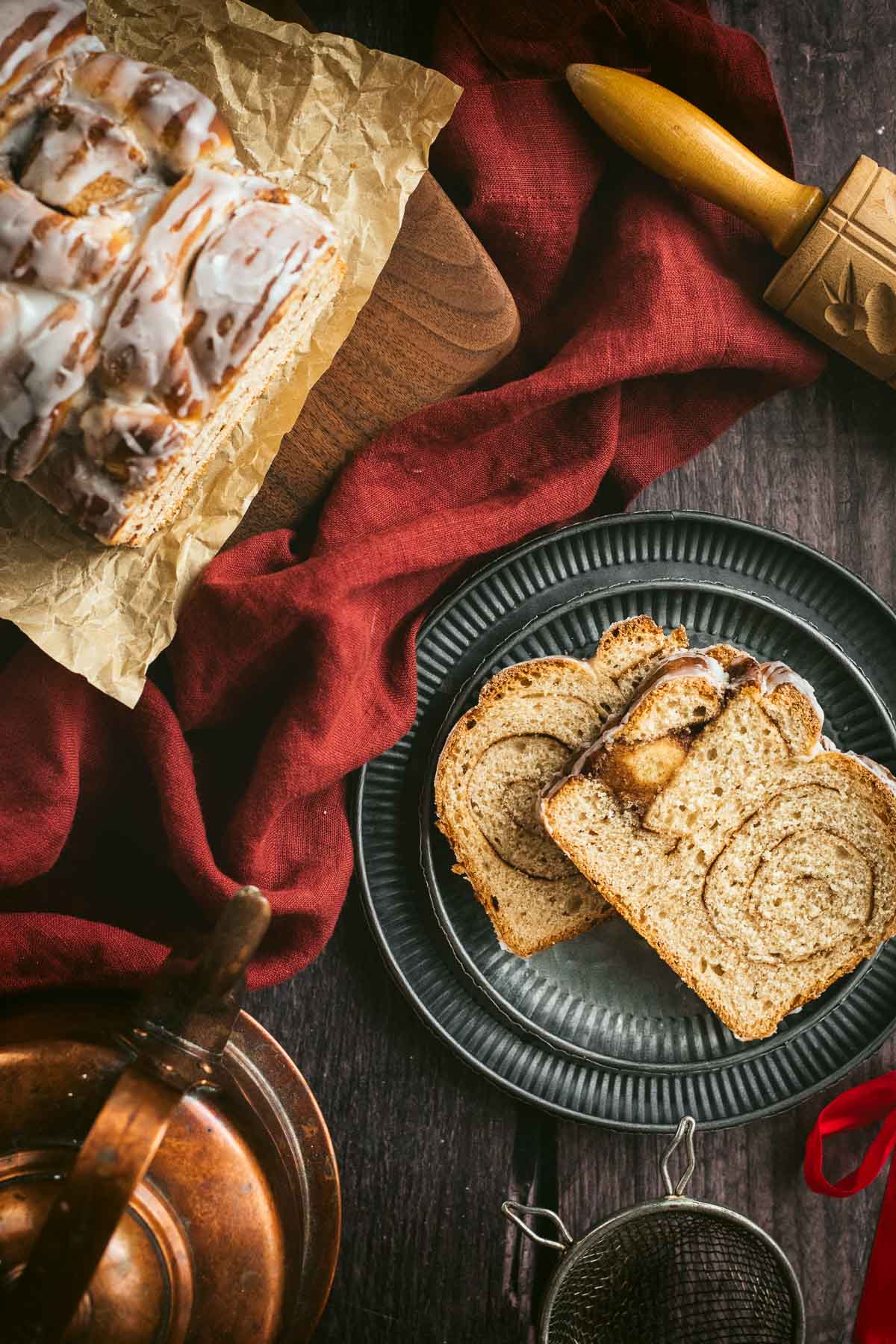 Two slices of cinnamon swirl bread on stacked metal plates.