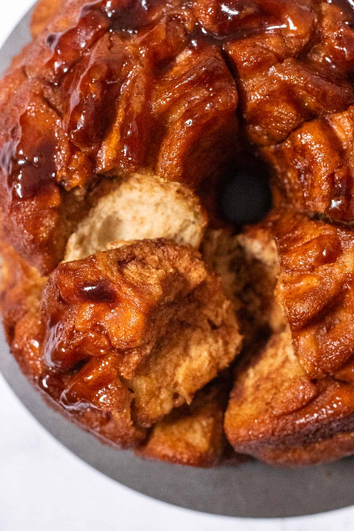 Syrup-coated pull apart bread buns on a metal serving platter.