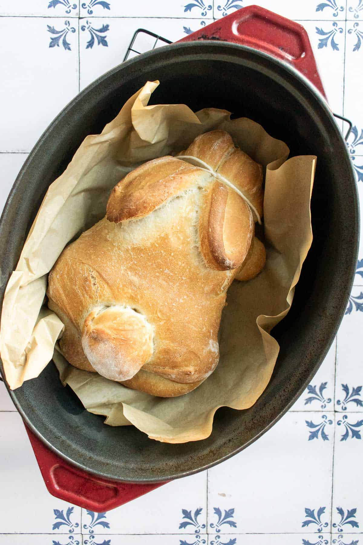 A baked loaf of bread in a Dutch oven shaped like a bunny.