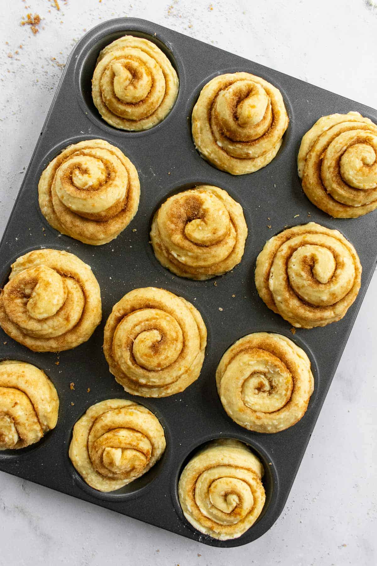 A muffin tin filled with unbaked morning buns.