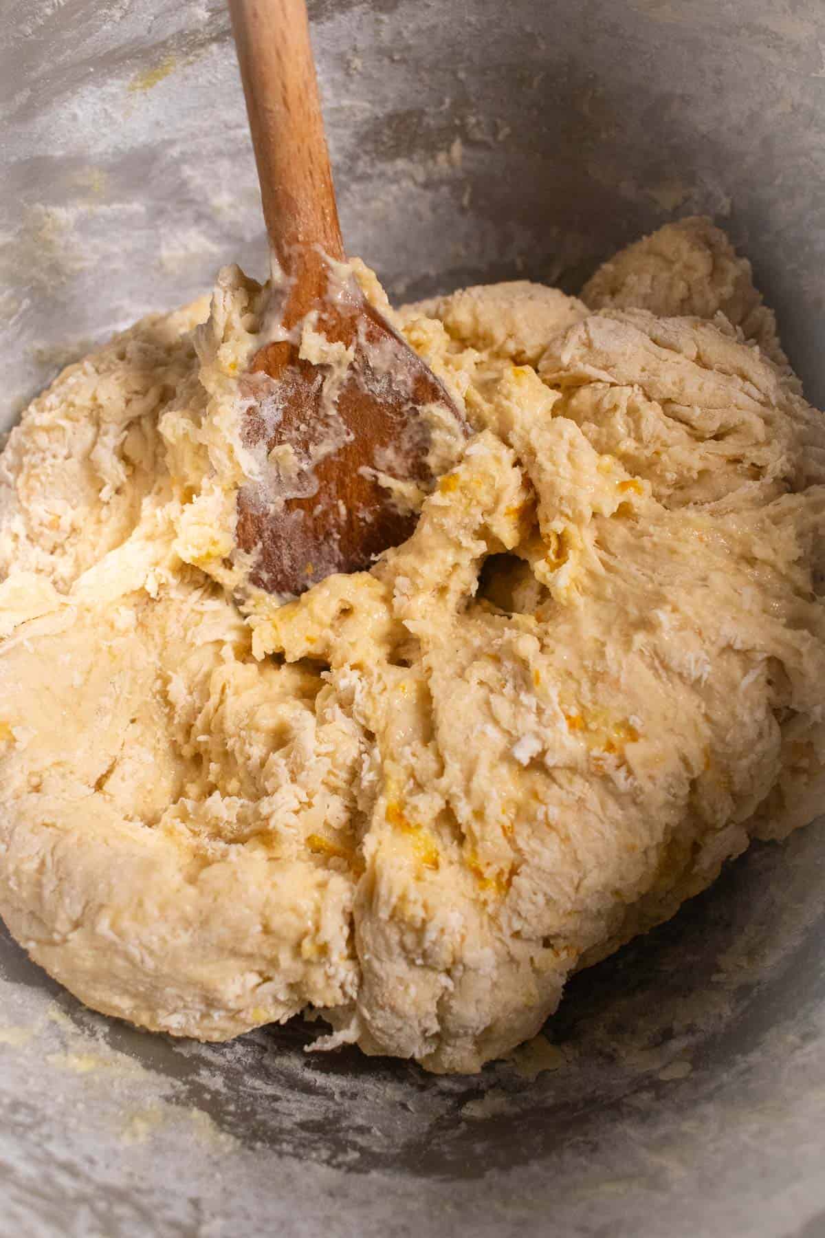 A sticky bread dough mixed in a metal bowl.