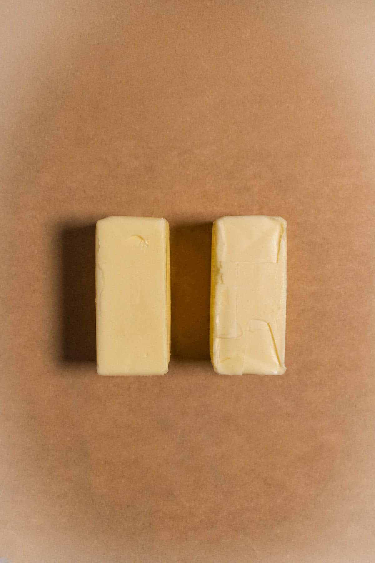 Two sticks of butter on parchment paper.