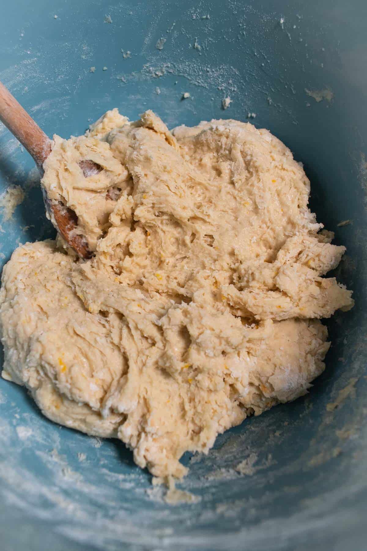 A shaggy bread dough in a blue mixing bowl.