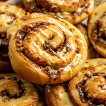 Half a dozen orange yeast rolls piled on a plate.