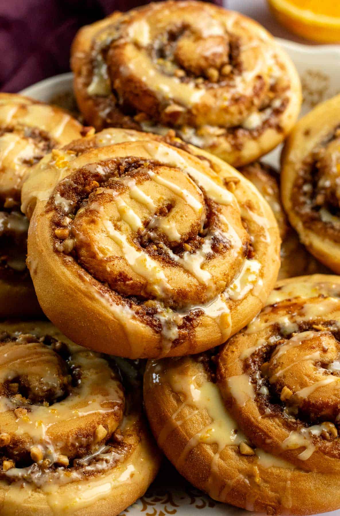 A stack of half a dozen orange yeast rolls on a plate.
