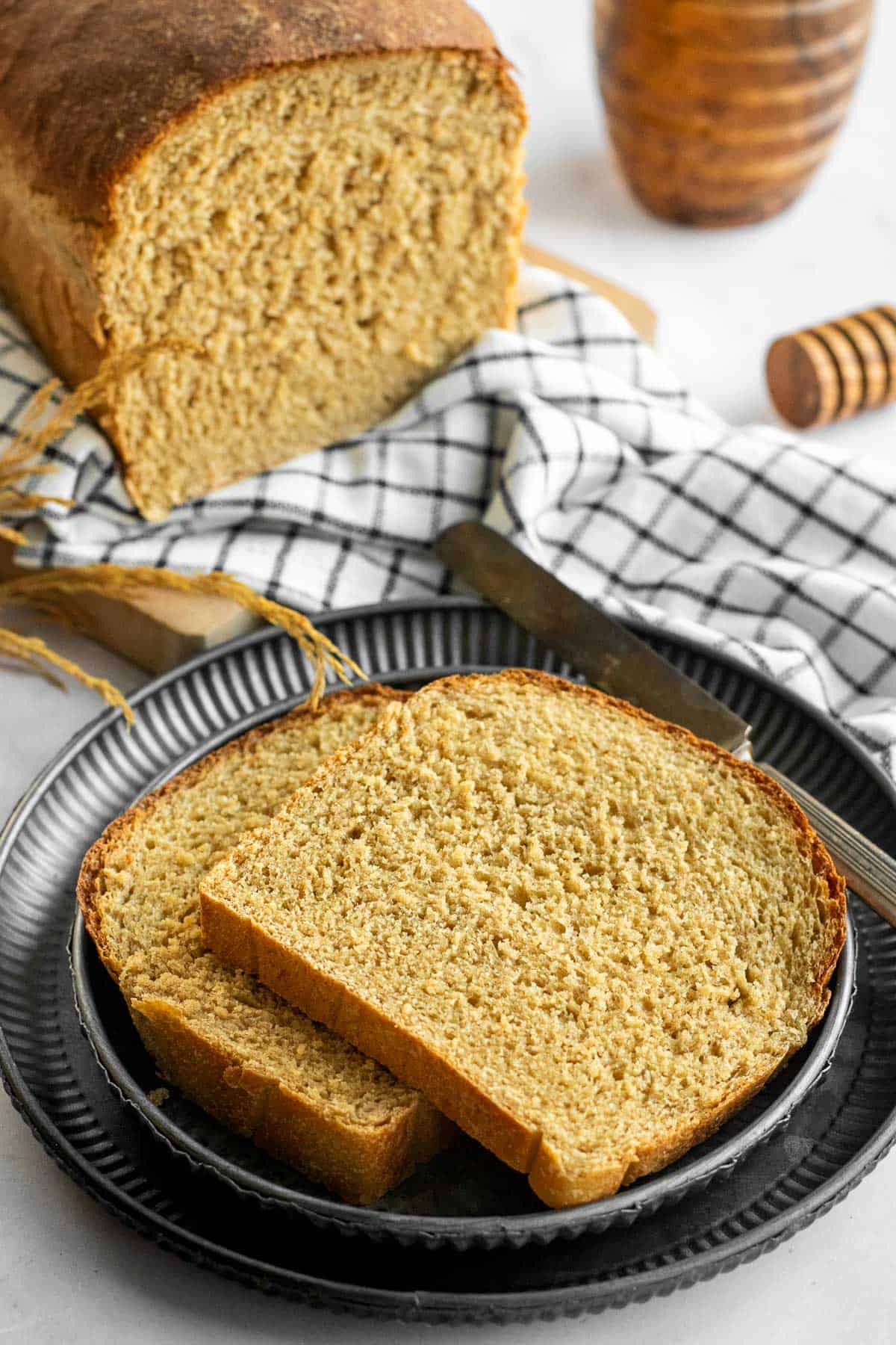 Two slices of wheat sandwich bread on stacked metal plates.