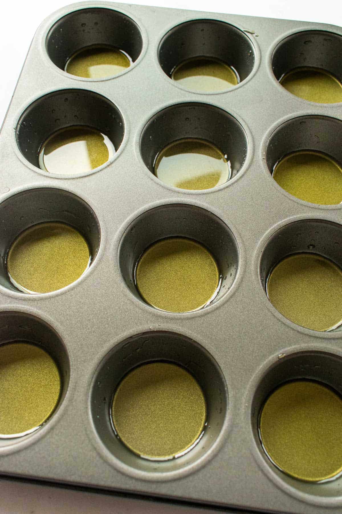 A metal muffin tin greased with olive oil.
