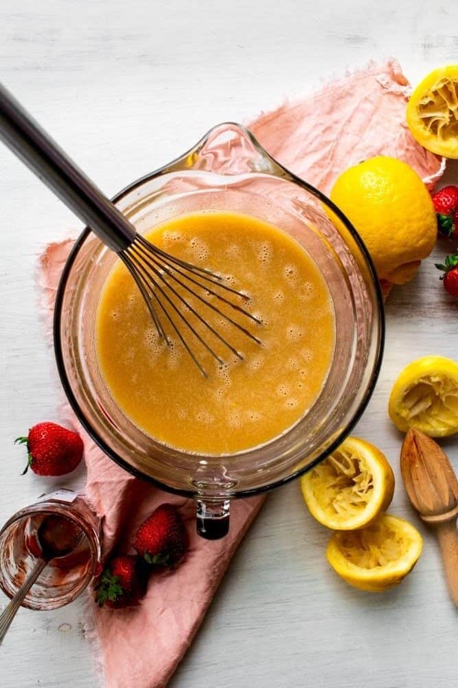 a glass bowl iwth a whisk and wet ingredients.
