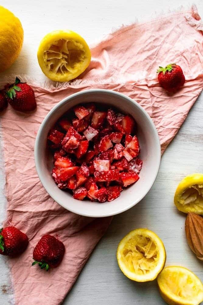 a white bowl filled with diced strawberries.