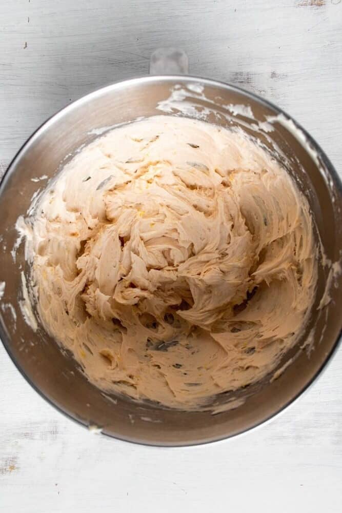 a large metal bowl filled with strawberry lemon buttercream.