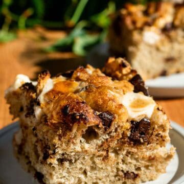 A large square of smores focaccia on a grey plate, with another slice in the background.