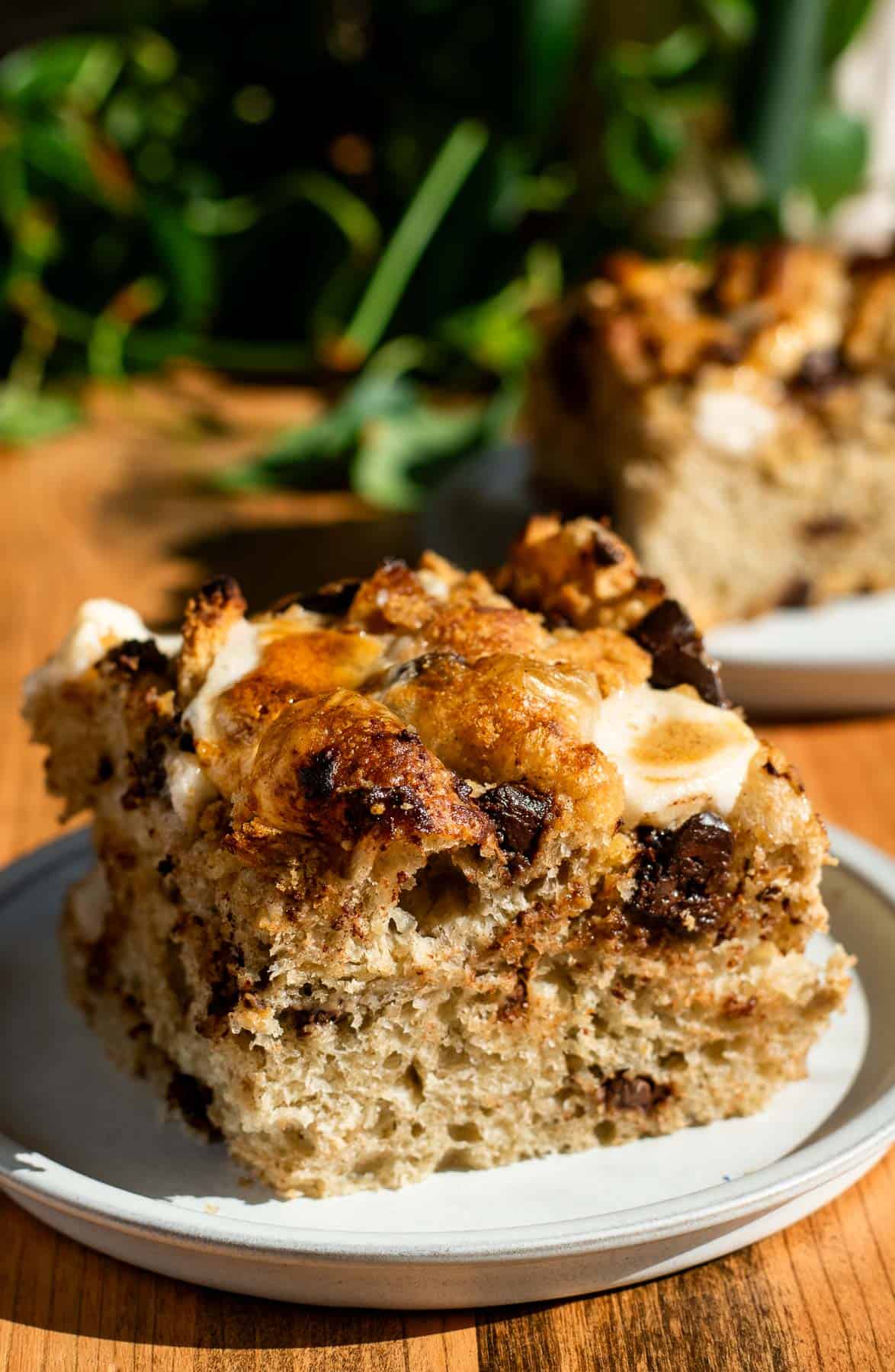 A large square of smores focaccia on a grey plate, with another slice in the background. 