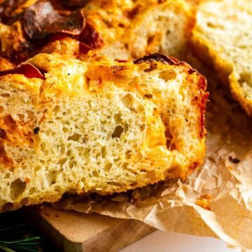 Slices of thick loaf pan focaccia topped with cheese and pepperoni.