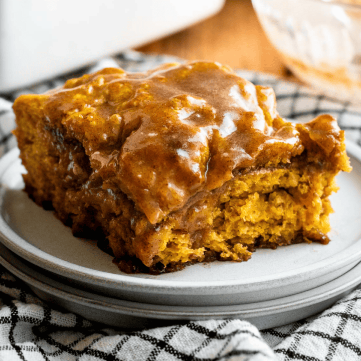 A large slice of pumpkin focaccia with a brown sugar cinnamon filling, topped with honey cinnamon glaze on a small grey plate.