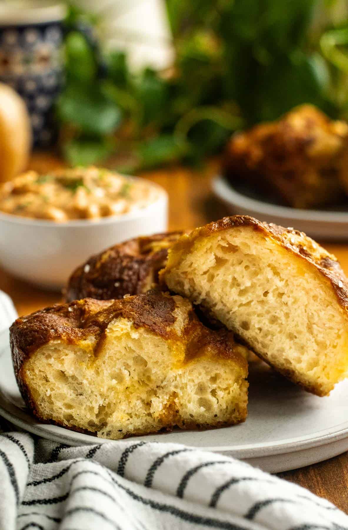 Two halves of a piece of pretzel focaccia showing the fluffy, open crumb, sitting on a small grey plate.