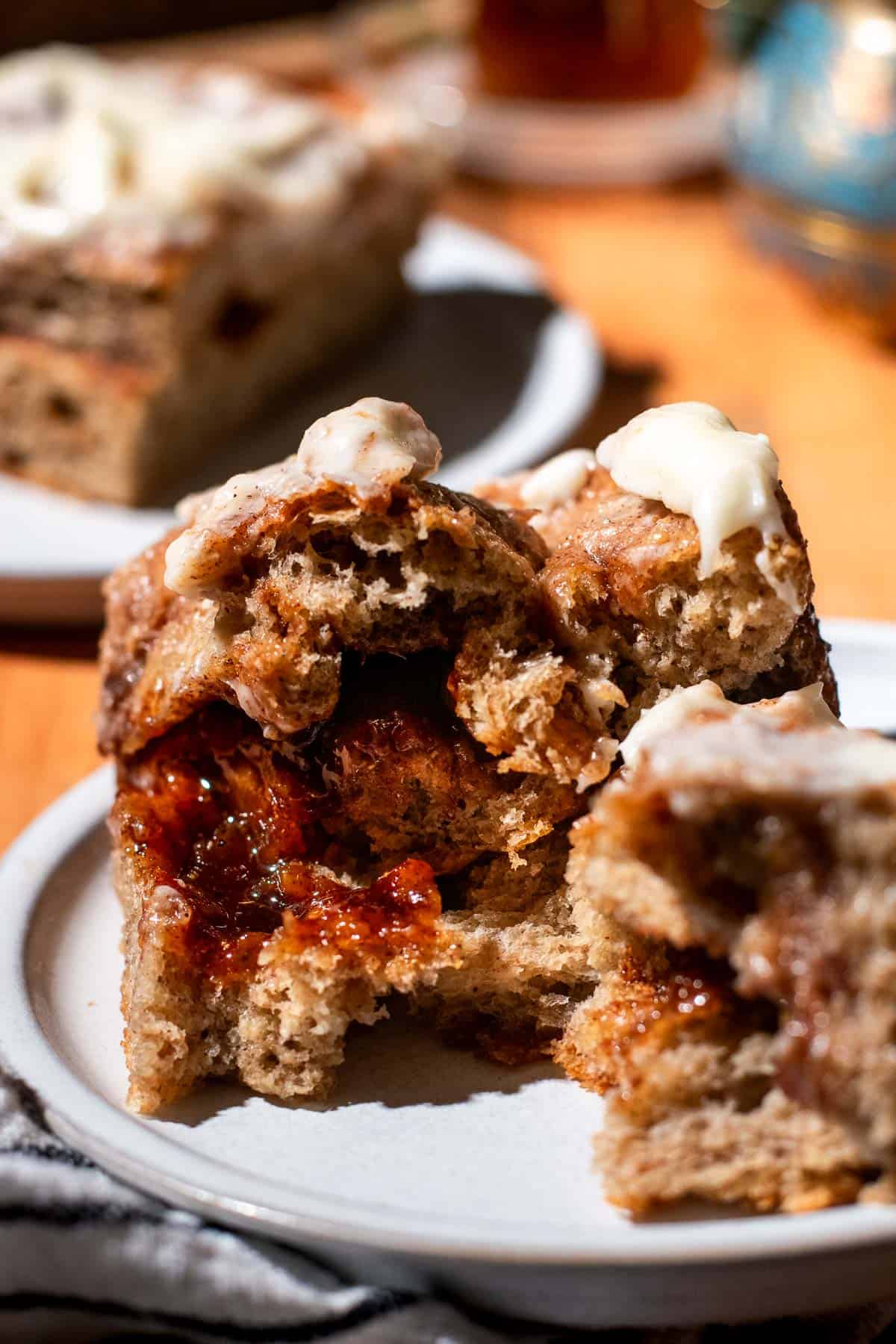 A large piece of snickerdoodle focaccia torn in half to show the gooey cinnamon sugar filling sitting on a grey plate.