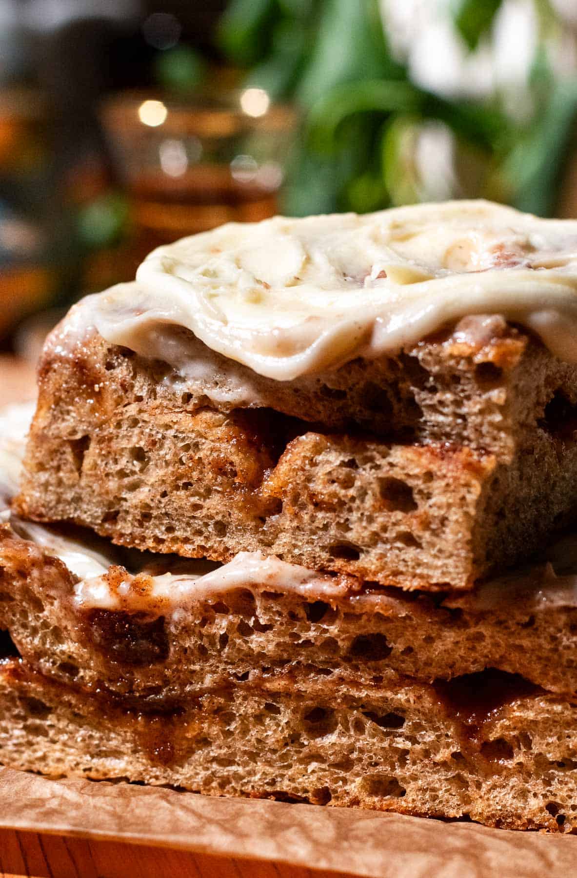 Two large pieces of chai focaccia with a cinnamon sugar filling stacked on top of each other and topped with cream cheese frosting.
