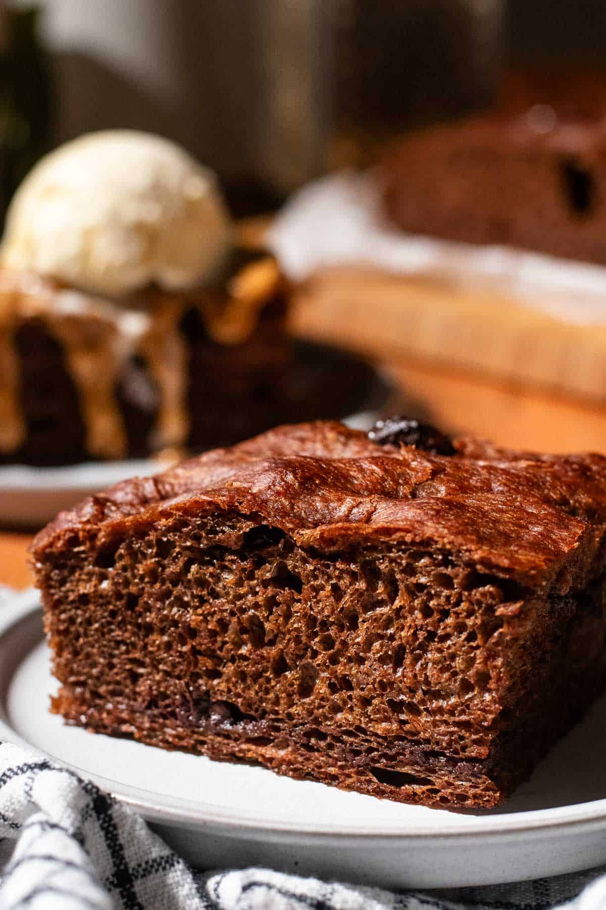 A thick square of chocolate focaccia bread on a small grey plate.